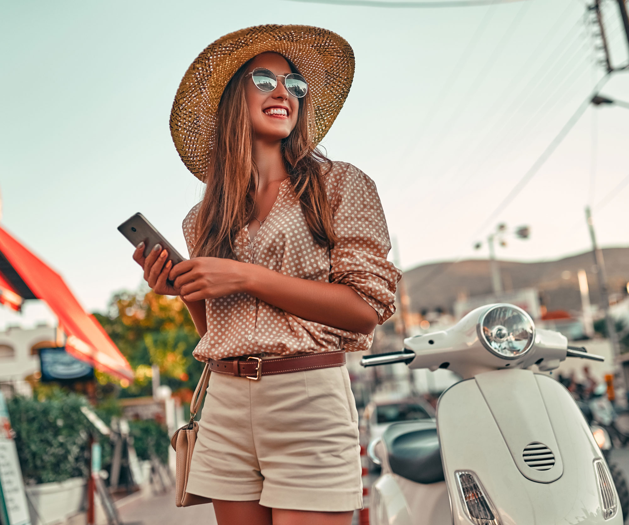 woman holding phone with Vespa Scooter